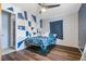 Bedroom featuring a geometric accent wall, a ceiling fan, and wood-look floors at 2272 Palomar St, North Port, FL 34287