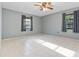 Bright bedroom featuring tile floors, a ceiling fan, neutral-colored walls, and two large windows at 2272 Palomar St, North Port, FL 34287