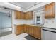 Kitchen featuring wood cabinets, stainless steel dishwasher, and tile floors at 2272 Palomar St, North Port, FL 34287