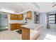 Bright kitchen with wood cabinets, breakfast bar, white tile floors, and natural lighting at 2272 Palomar St, North Port, FL 34287