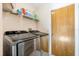 Laundry room with side-by-side stainless steel washer and dryer and shelving at 2272 Palomar St, North Port, FL 34287