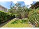 Spacious backyard featuring mature trees, a well-manicured lawn, and vibrant flower bushes at 2305 Riverview Blvd, Bradenton, FL 34205