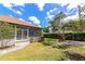 Landscaped backyard with a screened-in porch and lush greenery, perfect for outdoor entertaining at 2305 Riverview Blvd, Bradenton, FL 34205