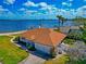 Waterfront home features a two-car garage, lush lawn, and stunning views of the water at 2305 Riverview Blvd, Bradenton, FL 34205