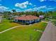 This is a view from the street, featuring landscaping, a screened porch and a shingled roof at 2305 Riverview Blvd, Bradenton, FL 34205