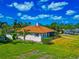 Well-maintained single-story home with a screened lanai, lush landscaping, and mature trees at 2305 Riverview Blvd, Bradenton, FL 34205