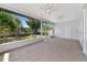 Screened-in patio with tile flooring, ceiling fans, and views of the serene backyard at 2305 Riverview Blvd, Bradenton, FL 34205