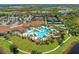 Breathtaking aerial view of a clubhouse and resort-style pool area with tennis courts and beautiful landscaping at 23261 Banbury Way # 501, Venice, FL 34293