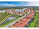 A picturesque aerial shot showcases a community with well-maintained homes nestled along a serene lake at 23261 Banbury Way # 501, Venice, FL 34293
