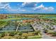 Aerial view features tennis courts and a clubhouse, surrounded by lush landscapes, a golf course, and sparkling lakes at 23261 Banbury Way # 501, Venice, FL 34293