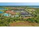 Beautiful aerial view of the community featuring a clubhouse, pool, tennis courts, and residential area at 23261 Banbury Way # 501, Venice, FL 34293