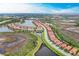 Wide aerial view showcasing community with numerous lakes, green spaces, and nearby highways at 23261 Banbury Way # 501, Venice, FL 34293