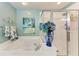 Bathroom with a garden tub, separate shower, beach-themed wall art and blue floral arrangement at 23261 Banbury Way # 501, Venice, FL 34293