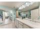 Bright bathroom featuring double sinks, modern vanity and garden tub with separate shower at 23261 Banbury Way # 501, Venice, FL 34293