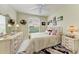 Bedroom featuring a queen bed, floral print bedding, and cream-colored furniture at 23261 Banbury Way # 501, Venice, FL 34293