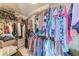 Walk-in closet with rods and shelves, filled with clothes and accessories for storage at 23261 Banbury Way # 501, Venice, FL 34293