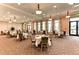 Well-lit dining room with multiple tables and chairs, scenic views, and floral curtains at 23261 Banbury Way # 501, Venice, FL 34293