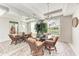 Elegant dining room featuring a glass table, wicker chairs, and large mirrors for an expanded feel at 23261 Banbury Way # 501, Venice, FL 34293