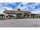 Elegant community entrance with a tile roof, decorative columns, and lush landscaping at 23261 Banbury Way # 501, Venice, FL 34293