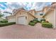 Inviting townhome with a brick driveway, a two-car garage, and well-manicured landscaping at 23261 Banbury Way # 501, Venice, FL 34293