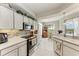 Well-lit kitchen features stone backsplash, pendant lights and stainless steel appliances at 23261 Banbury Way # 501, Venice, FL 34293