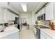 Updated kitchen features white cabinets, stainless steel appliances, and tiled flooring at 23261 Banbury Way # 501, Venice, FL 34293