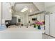 Bright kitchen featuring white cabinets, modern appliances, and a stylish breakfast bar with overhead lighting at 23261 Banbury Way # 501, Venice, FL 34293