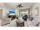 Bright living room with view to lanai featuring tile floors and ceiling fan at 23261 Banbury Way # 501, Venice, FL 34293