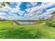 Picturesque view of a pond surrounded by lush greenery on a sunny day at 23261 Banbury Way # 501, Venice, FL 34293