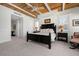 This bedroom features a wooden trey ceiling, a ceiling fan, a black bed frame, and lots of natural light at 2333 Gulf Of Mexico Dr # 1A2, Longboat Key, FL 34228