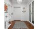 Hallway entrance featuring dark wood floors, white walls and nautical decoration at 2333 Gulf Of Mexico Dr # 1A2, Longboat Key, FL 34228