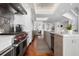 This kitchen is long and features stainless steel appliances, a kitchen island with a marble countertop, and hardwood flooring at 2333 Gulf Of Mexico Dr # 1A2, Longboat Key, FL 34228