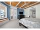 Bright main bedroom boasts wooden ceilings, blue accent wall, and large windows offering picturesque views at 2333 Gulf Of Mexico Dr # 1A2, Longboat Key, FL 34228