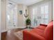 Cozy sitting area with nautical decor, red sofa, and french doors for access to fresh air at 2333 Gulf Of Mexico Dr # 1A2, Longboat Key, FL 34228