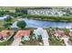 Aerial view showcasing the waterfront home, and landscaping at 2435 E Del Webb Blvd, Sun City Center, FL 33573