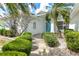 Charming front entrance with a blue door, lush landscaping, and a well-maintained walkway at 2435 E Del Webb Blvd, Sun City Center, FL 33573