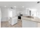 Well-lit kitchen with white cabinetry, a functional island, and an open layout with view to the breakfast nook at 2435 E Del Webb Blvd, Sun City Center, FL 33573