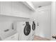 Modern laundry room with front-load washer and dryer, sink, and plenty of storage at 2435 E Del Webb Blvd, Sun City Center, FL 33573