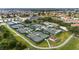 Aerial view showcases multiple fenced tennis courts in a community with lush greenery at 2435 E Del Webb Blvd, Sun City Center, FL 33573