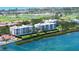 Waterfront condo building boasting beautiful bay views, a manicured lawn, and lush landscaping at 2450 Harbourside Dr # 251, Longboat Key, FL 34228