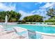 Community pool with plenty of lounge chairs, surrounded by lush greenery at 2450 Harbourside Dr # 251, Longboat Key, FL 34228
