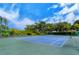 Well-maintained tennis court surrounded by lush greenery at 2450 Harbourside Dr # 251, Longboat Key, FL 34228