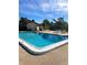 Community swimming pool surrounded by lounge chairs and lush landscaping at 2601 Pine Lake Ter # B, Sarasota, FL 34237