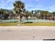 Community tennis court with players and a palm tree nearby at 2601 Pine Lake Ter # B, Sarasota, FL 34237