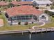 Aerial view of a waterfront home with a screened-in pool, dock, and beautifully landscaped backyard at 2817 La Mancha Ct, Punta Gorda, FL 33950