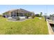 Spacious backyard featuring a screened-in lanai, beautiful landscaping, and waterfront views at 2817 La Mancha Ct, Punta Gorda, FL 33950