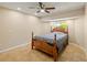 Cozy bedroom features a ceiling fan, neutral walls, tile floors, and a wooden bed frame at 2817 La Mancha Ct, Punta Gorda, FL 33950
