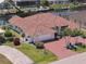 Waterfront home with a tile roof, lush landscaping, brick driveway, and an attached garage on a well-manicured lot at 2817 La Mancha Ct, Punta Gorda, FL 33950
