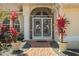 Elegant front entrance with decorative dolphin doors, lush plants, and a brick walkway at 2817 La Mancha Ct, Punta Gorda, FL 33950