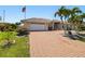 Charming home with a brick driveway, mature landscaping, and a two-car garage at 2817 La Mancha Ct, Punta Gorda, FL 33950